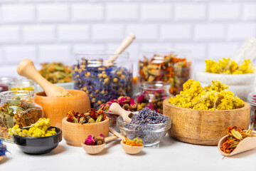 Assortment of dry herbal and berry tea on a wooden background. Tea party concept. medicinal herbs. Healing herbs.Alternative medicine.Linden, calendula, cornflowers, marigold, tansy, tea rose.