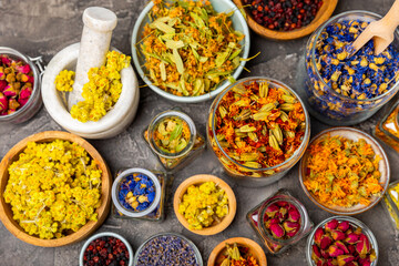 Assortment of dry herbal and berry tea on a wooden background. Tea party concept. medicinal herbs. Healing herbs.Alternative medicine.Linden, calendula, cornflowers, marigold, tansy, tea rose.
