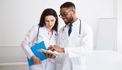 Coworking At Medicine. Doctor Giving His Colleague Piece Of Advice during Meeting With Staff In Hospital