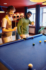 Fototapeta premium Friends play a friendly game of billiards in a casual setting.