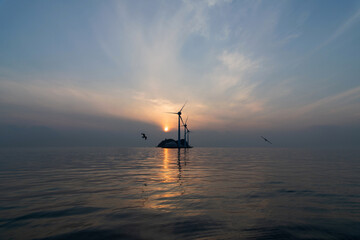 Fototapeta premium View of the wind turbines and flying seagulls during sunset on the sea