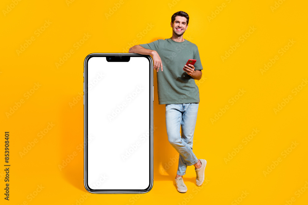 Poster full length photo of cool positive man dressed khaki t-shirt typing messages modern gadget empty spa
