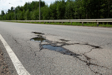 Potholes on bad asphalt road. Closeup