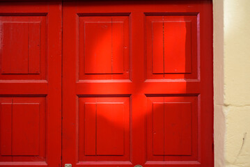 Luz solar en puerta de madera pintada de rojo