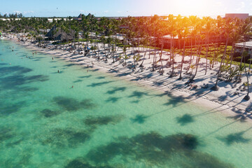 Sunset or sunrise on tropical beach with resorts, palm trees and caribbean sea. Dominican Republic. Aerial view