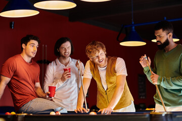 Friends play billiards in a dimly lit room.