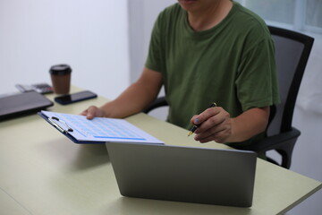 Fototapeta premium Looking at busy businessman's hands Using smartphones and laptops in the office, AI creates images.