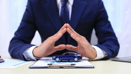 Car insurance documents or rental concept. A car broker helps his customers and explains the details of car contacts. Car keys. Buy or sell, sign.