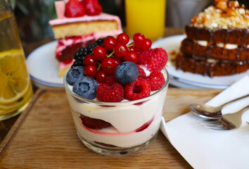 berry desserts and chocolate cake on a wooden table in the interior of the room