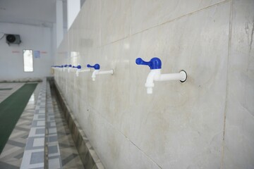 White plastic tap in the mosque ablution area, good for news, articles, posters, advertisements and...