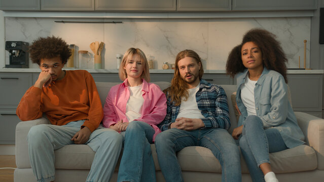 Multiracial people multiethnic friends diversity students Caucasian women female girls African American men male guys together home couch sofa watching boring TV show movie bad film bored talking yawn