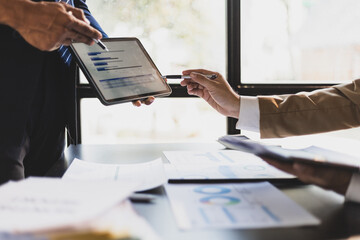 Business people meeting discuss project plan and finance results in office. Businessman financial advisor analyzing the financial data graph and charts on the tablet screen.