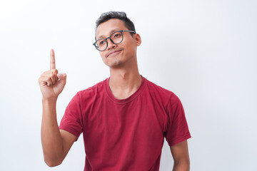 Young Asian man poses on one finger with a thin smile, wearing a red t-shirt isolated on a white background. Shot in studio.