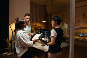 Positive team of developers discussing new mobile app interface
