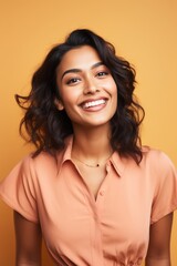 
Portrait photo of a cheerful Indian woman, 27 years old, winking on a pastel orange background