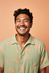 
Portrait photo of a joyful Pacific Islander man, 33 years old, winking on a pastel beige background