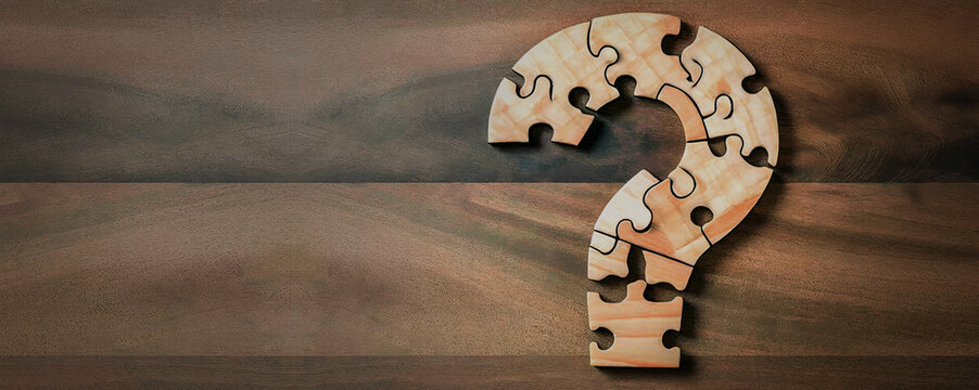 Puzzle question mark on wooden background, concept for assessments, test, exam, quiz, puzzle, knowledge checks backgrounds, concept of help, concept of solution.