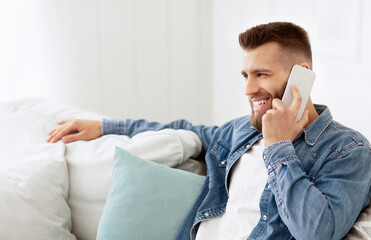 Handsome Man Talking On Phone, Relaxing On Sofa At Home, Free Space