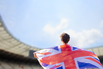 An athlete with the British flag draped over their shoulders, representing the United Kingdom in...