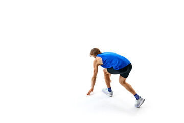 Ready, steady, go. Athletic man, runner standing on starting line, ready for running isolated on white studio background. Concept of sport, marathon, competition, healthy and active lifestyle