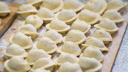 Homemade dumplings close-up. handmade dumplings on a wooden board, selective focus, tinted image, traditional Russian dish,