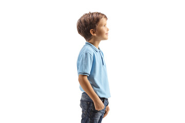 Profile shot of a boy in a blue t-shirt standing and watching something