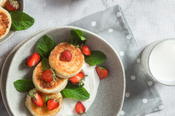 Homemade cottage cheese pancakes with sauce and strawberries. syrniki