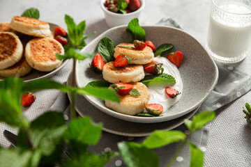 Homemade cottage cheese pancakes with sauce and strawberries. syrniki