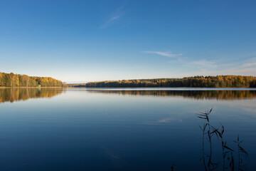 A calm lake with a blue sky in the background