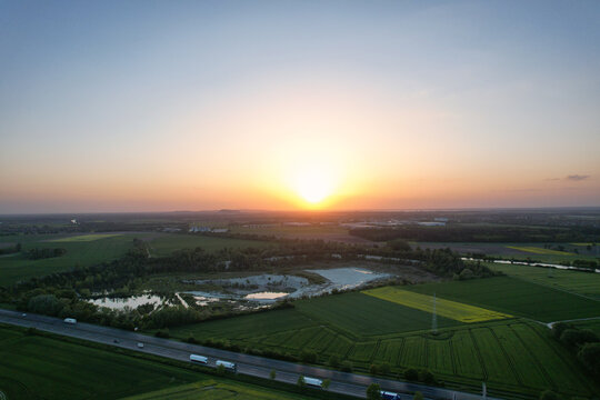 An aerial view of a sunset over a green field with a beautiful sky and clouds 5K FPV drone view Hanover Kolenfeld Germany 