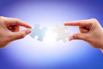 Human connecting colored two pieces of puzzle.