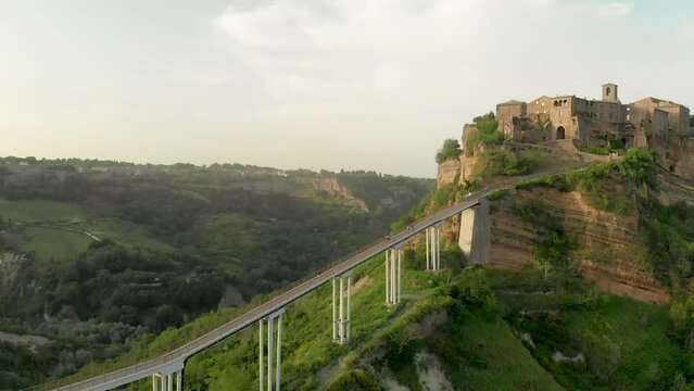 Aerial summer evening view of famous Civita di Bagnoregio town, beautiful place located on top of a volcanic tuff hill overlooking the Tiber river valley. The place has Etruscan and Medieval origins.