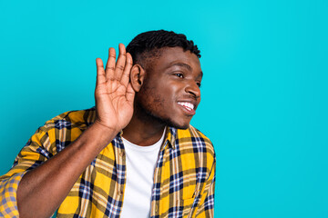 Photo of funny cheerful man wear trendy checkered clothes listen news empty space isolated on cyan...