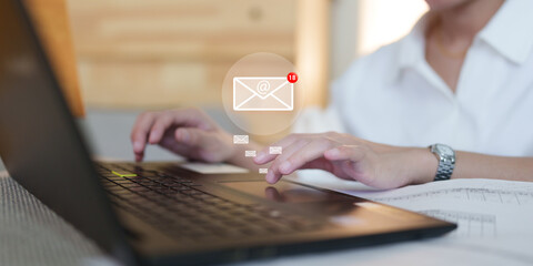 Person typing on a laptop with a digital email notification icon displaying unread messages