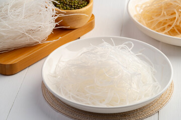 Fresh Glass Noodle in white plate with Dry Glass Noodle on wooden plate (Transparent bean...