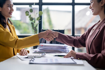 Two women shaking hands in a business setting