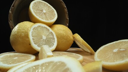 Close up of lemon slices are meticulously arranged against a rustic basket backdrop on a deep black...