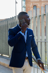 Smiling Stylish Young African American Man Talking on Phone in City