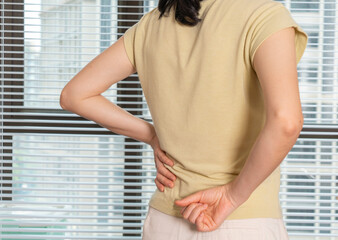 Women with lower back pain, pressing on the waist with their hands