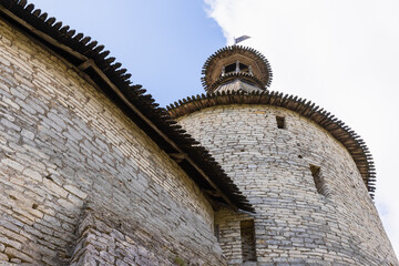 Stone fortress tower and walls with wooden roofs. Kremlin of Pskov