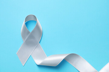 International Psoriasis Day. Ribbon as symbol of support on light blue background, top view. Space...
