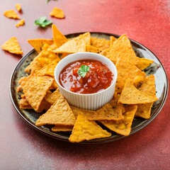 Spicy snack nachos with chutney on red background
