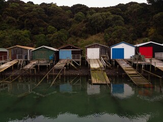 Historic colorful wooden boat sheds on Duvauchelle Bay shore in Akaroa Harbour, Banks Peninsula,...