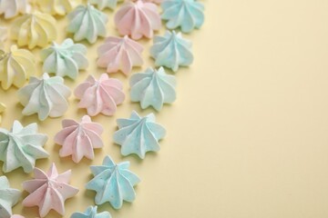 Delicious meringue cookies on beige background, closeup. Space for text