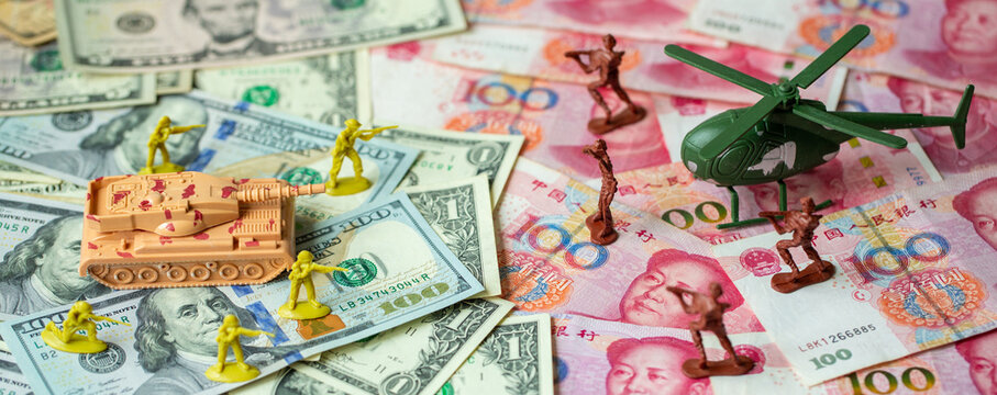 Toy set, tank, soldiers and helicopter placed on US banknotes, dollar currency pile and china banknotes, yuan currency. business and economy war. new world war from business and economy concept.