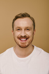 Obraz premium A stylish man with a beard smiles brightly.