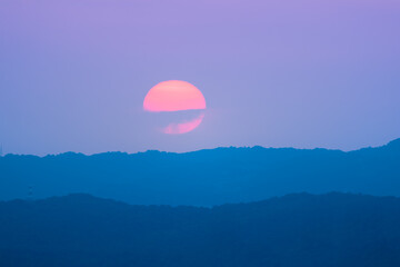 Beautiful yellow-orange sunset with mountain silhouette. Landscape of the dusk sky at Dajianshan. Xizhi District, New Taipei, Taiwan.