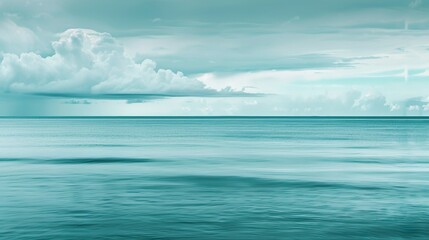 Obraz premium A photograph of a calm ocean with a dominant aquamarine hue.