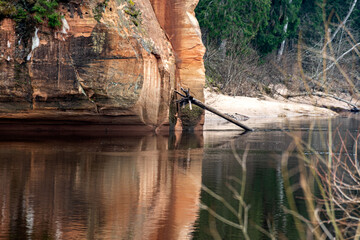 landscape with sandstone cliffs on the river bank, sandy river bank, old last year's grass, nature...
