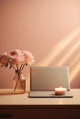Laptop with a cup of coffee, vase with flowers and candle